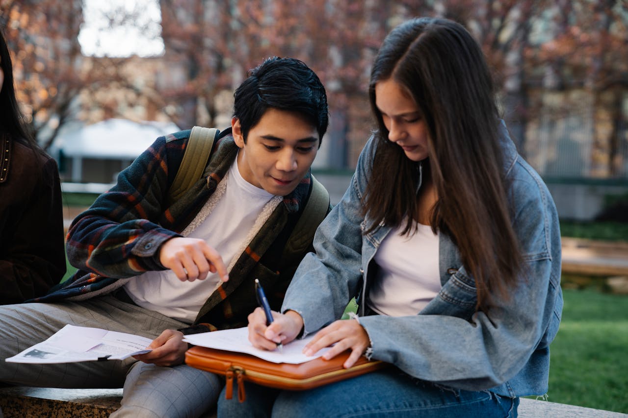 Two students working together on a study project outdoors.